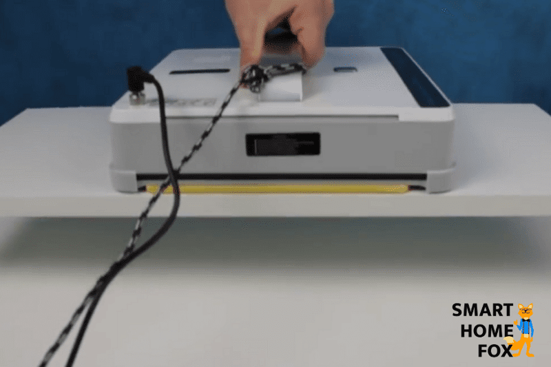 Es ist zu sehen, wie ein Fensterputzroboter einen Holzbalken hochhebt